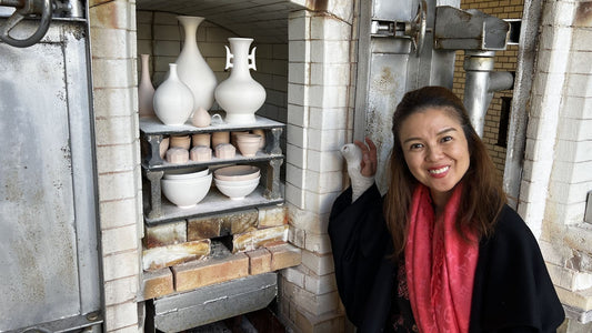 Japanese ceramic artisan beside a traditional pottery kiln