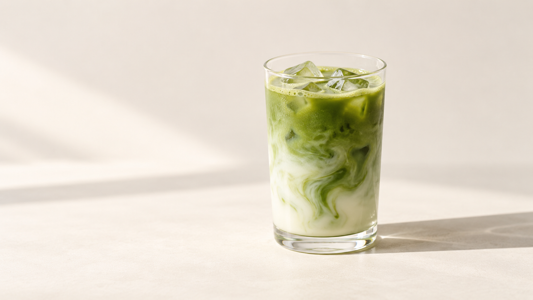 Iced matcha latte with green matcha and creamy milk in a clear glass.